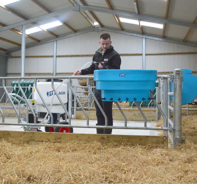 Milk Kart MK170MP3, 170L blue mixer-pump unit on a metal frame by JFC Agri in a livestock barn.