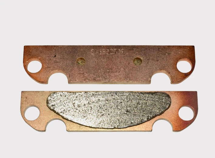 Brake Pads for Kioti Mechron Hand Brake (2 pcs), copper-toned bodies.