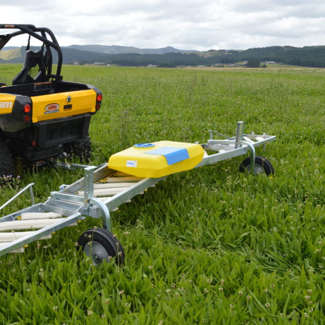 C-Dax Eliminator On-Board Tank 50L with 12V pump weed-wiper accessory on a metal trailer frame in a grassy field.