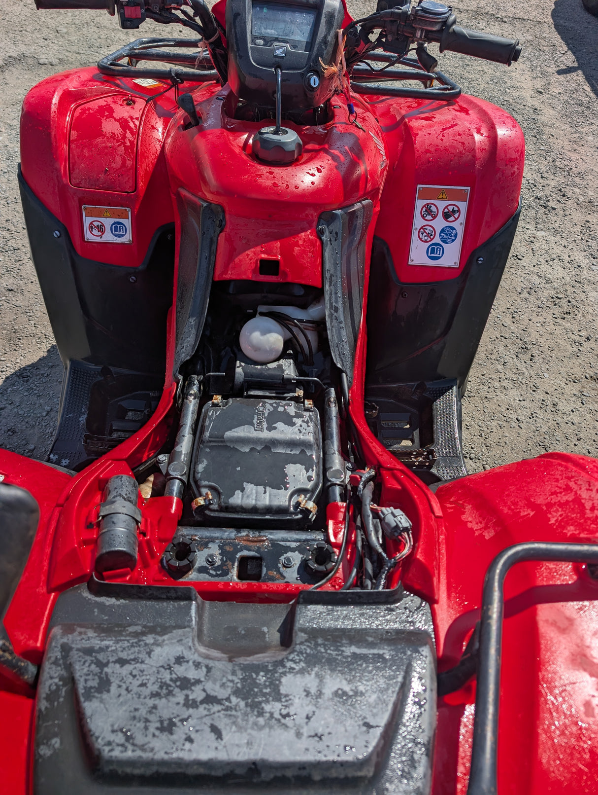 Honda TRX 500 ATV by DGT Agri; red, mud-splattered front view with warning decals.