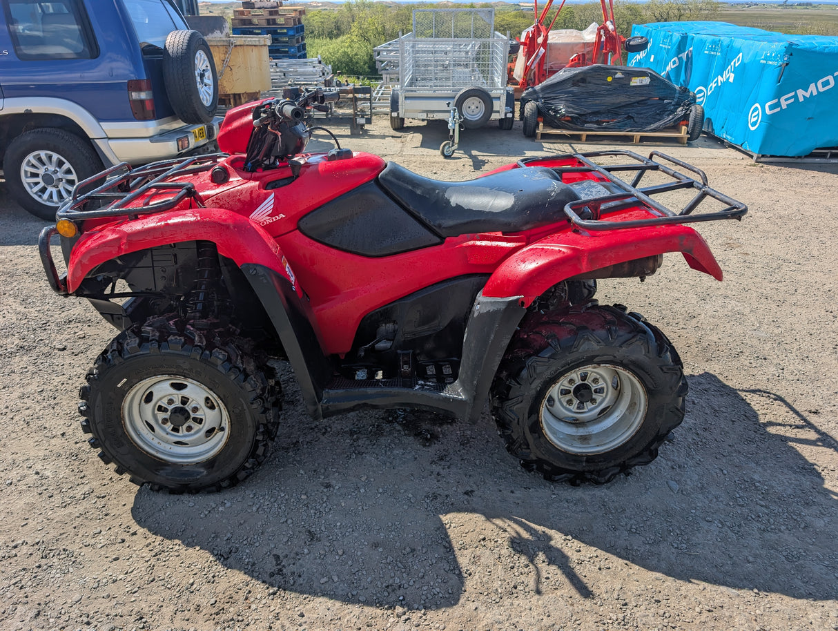 Honda trx 500 ATV red with black seat, front and rear cargo racks, knobby off-road tires