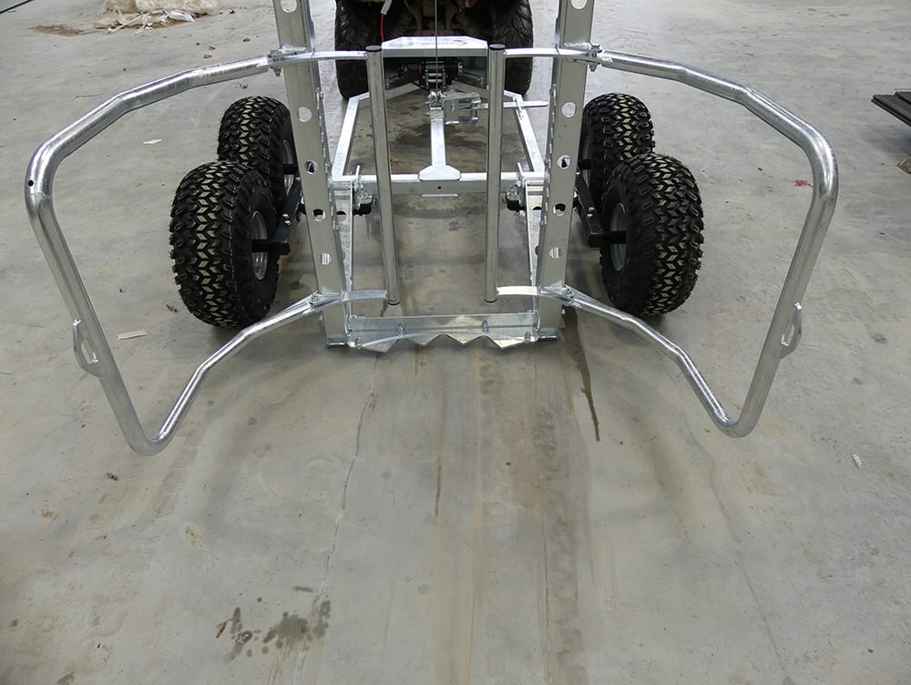 ATV bale transporter trailer with twin-axle metal frame and rugged off-road tires.