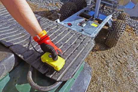 Chapman DT100 hydraulic dump trailer for ATV/UTV with rugged metal bed, large off-road tires, and yellow control box.