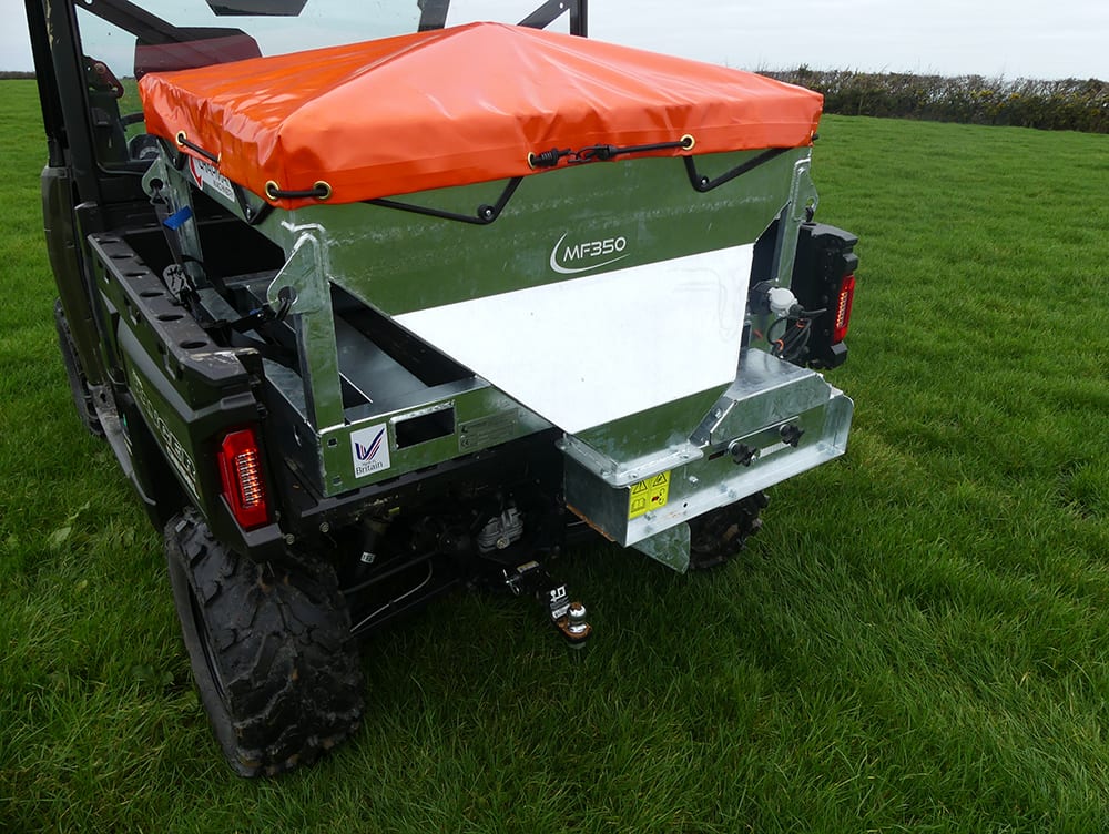 Chapman MF350 UTV-mounted stock feeder with orange tarp cover on green metal hopper