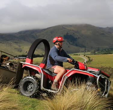 LifeGuard CPD & Mounting – Trax Red ATV with rider on a grassy hillside