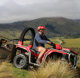 LifeGuard CPD & Mounting – Trax Red ATV with rider on a grassy hillside