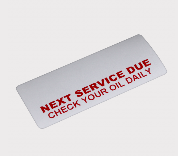 Service reminder sticker roll - DGT Agri; white label with red text NEXT SERVICE DUE CHECK YOUR OIL DAILY
