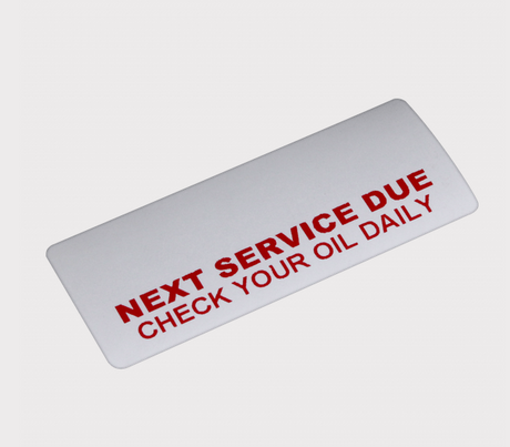 Service reminder sticker roll - DGT Agri; white label with red text NEXT SERVICE DUE CHECK YOUR OIL DAILY