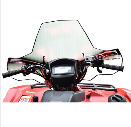 Windscreen Cobra Pro-Tek Universal ATV with central headlight cut-out on red ATV cockpit, clear plastic.