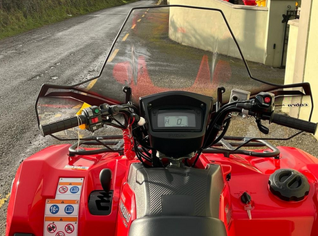 Windscreen for Cobra Pro-Tek Universal ATV (no headlight cut-out) mounted on a red ATV.