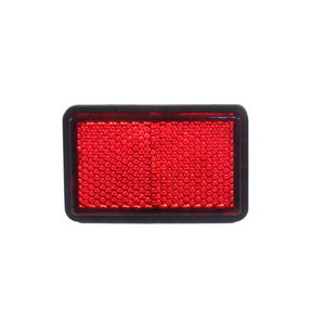 Rectangular red reflector with black outer frame and textured reflective surface