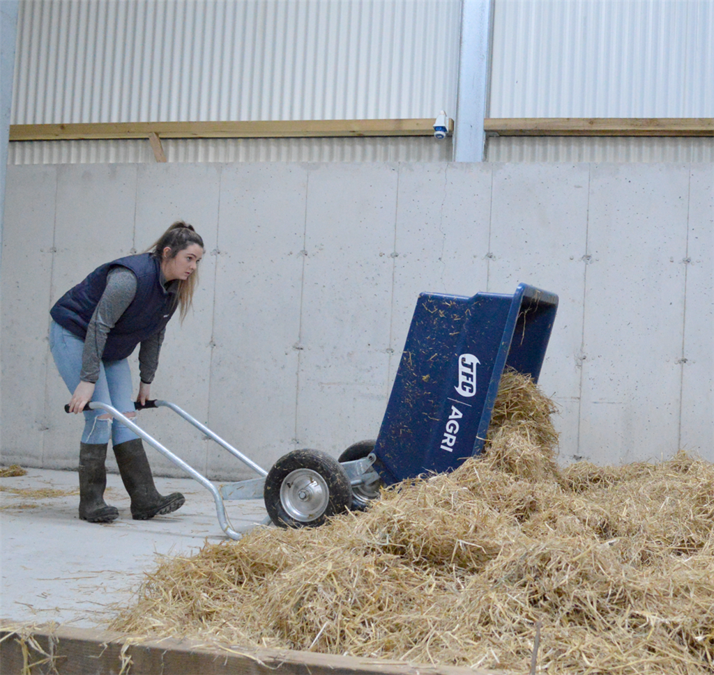 JFC Agri 250L tipping wheelbarrow, blue heavy-duty polyethylene with pneumatic wheels, shown tipping hay.
