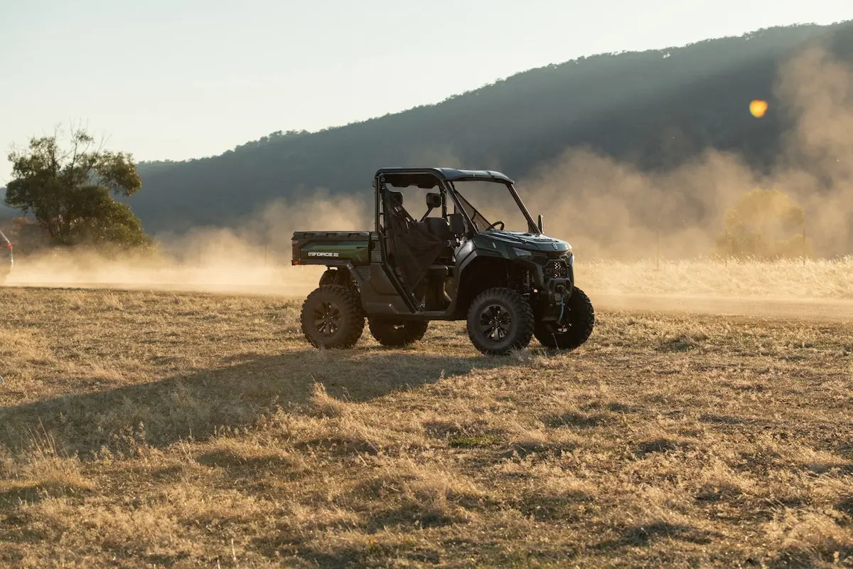 CFMOTO UFORCE U10 Pro Agri UTV in dark green/black 4x4 with roll cage on a dusty field.
