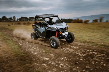 CFMOTO ZFORCE 950 Sport UTV, gray body with red shocks, tearing across dirt on an off-road trail