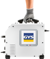 GYS EasyMIG 130 welder with accessories; white compact unit gripped by gloved hand on top handle