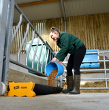 JFC Agri Corri Feed Trough CFT-375 110L blue trough in barn, person pouring grain from a blue bucket.