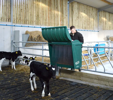 JFC Agri creep feeder 60kg with hinged lid, green livestock feeder in barn with cows.