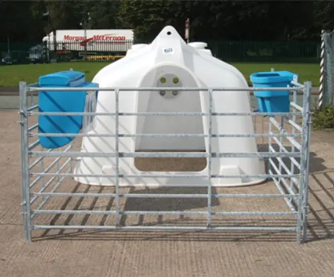 JFC Agri white compact calf hutch with metal pen and two blue feed troughs.