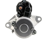 Denso gear reduction tractor starter motor, black housing with silver mounting flanges and copper terminal.