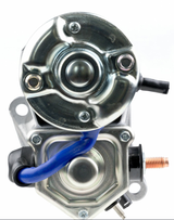 Denso starter motor with blue wire, metallic housing, and copper terminal post