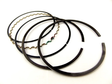 Piston ring kit for ATV engines with multiple black compression and oil rings on white background
