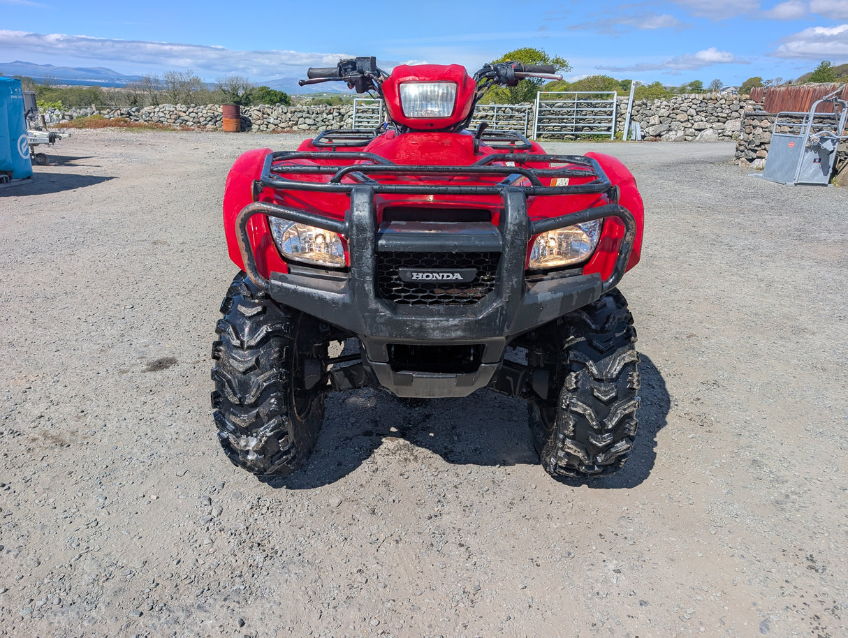 ATV Honda TRX 500 red front view with rugged bumper and large knobby tires