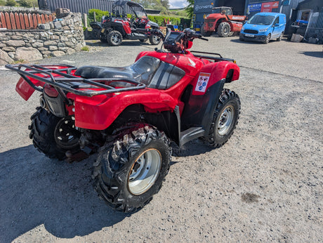 Honda TRX 500 ATV, red with black seat and rugged all-terrain tires