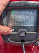 Honda TRX 500 ATV dashboard in red with a green neutral indicator and Honda emblem
