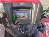 Honda TRX 520 FM6 ATV dashboard, red body, black console with Honda emblem, digital readout 0 mph, N gear, raindrops.