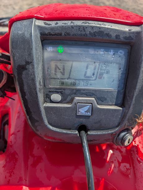 Honda trx 500 ATV dashboard with red body, dusty black plastic housing, green neutral indicator, Honda emblem