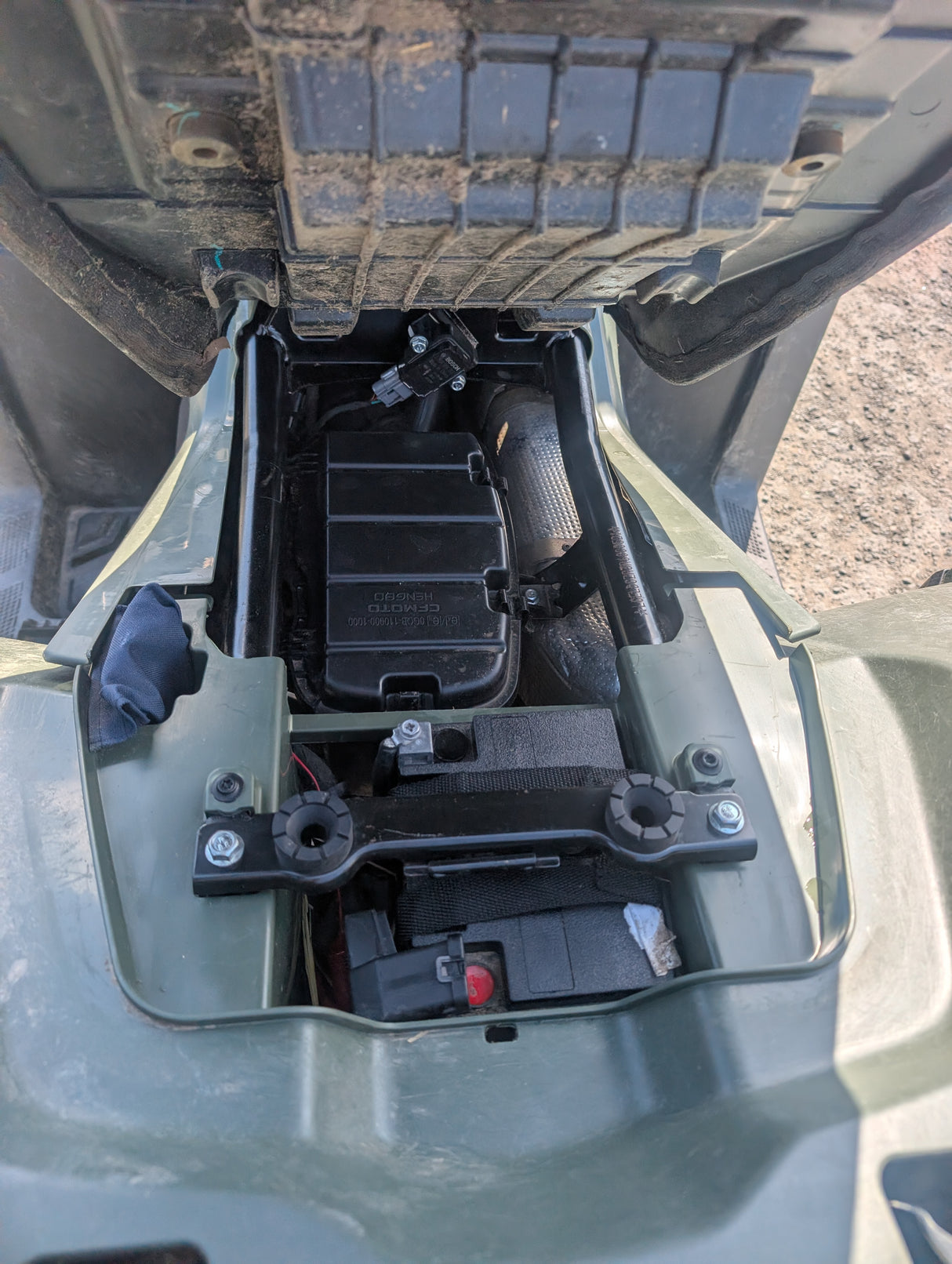 Used CFMOTO CFORCE 450 ATV under-seat battery compartment with wiring harness, olive-green body.