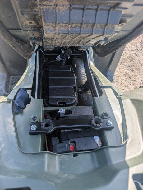 Used CFMOTO CFORCE 450 ATV under-seat battery compartment with wiring harness, olive-green body.