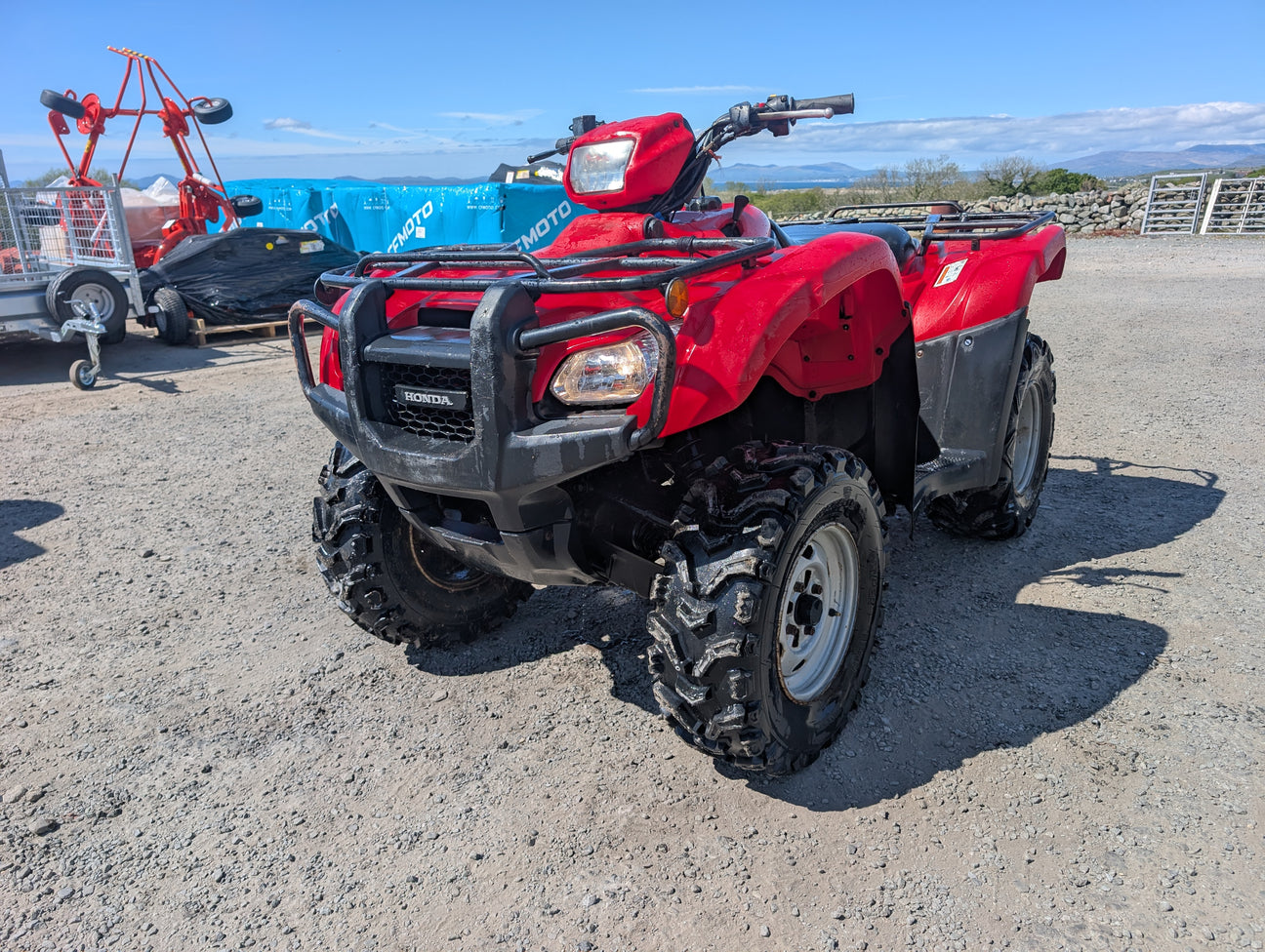 Honda TRX 500 ATV in red with black front bumper and rugged tires.