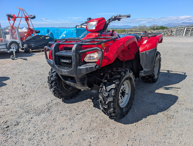 Honda TRX 500 ATV in red with black front bumper and rugged tires.