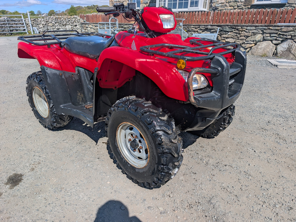 Honda TRX 500 ATV red with front and rear racks, rugged tires
