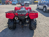 Honda TRX 500 ATV red quad bike with rugged off-road tires in a dealership yard