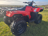 Red Honda TRX 520 FM6 manual ATV with black rear cargo rack and rugged off-road tires