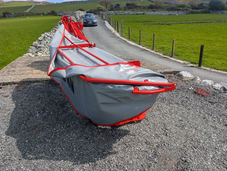 KUHN GMD 240-FF 2.4m 6-disc disc mower on rural road; red frame, grey cover.